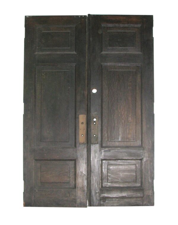 Pair of antique three-panel double doors with a very dark wood tone and some original hardware visible.