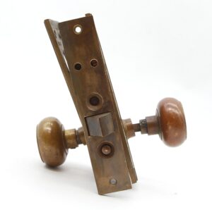 Bronze entry door knob set with two round knobs and a tall mortise plate shown at an angle.