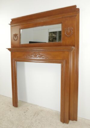 Close-up of a dark wood Victorian mantel showing carved trim, a decorative beaded band, and minor surface chips.