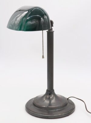 Antique bankers desk lamp with a fluted stem, green and white Emeralite shade, pull chain switch, and round base.