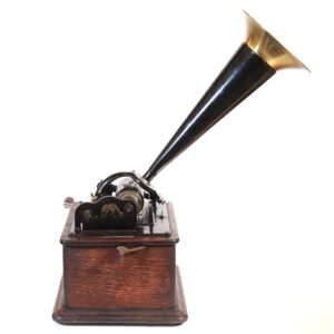 Antique phonograph with a long horn and oak base, shown in a three-quarter view.