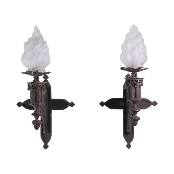 Pair of Gothic wall sconces with frosted flame-shaped glass shades and ornate cast iron mounts shown front and side by side.