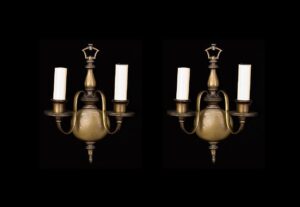 Pair of two-arm wall sconces with oil-rubbed bronze finish and candle-style holders, shown front on.
