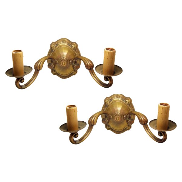 Pair of Art Nouveau bronze double-arm wall sconces with two candle-style holders and ornate backplates, shown as a matching pair.