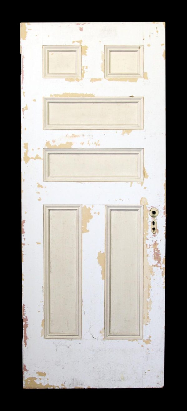 Six-panel wood door with a white painted surface and tan trim, shown front view with worn paint and door hardware on the right edge.