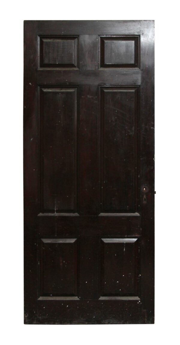 Six-panel door in a dark wood tone, shown front view with a keyhole on the right side.