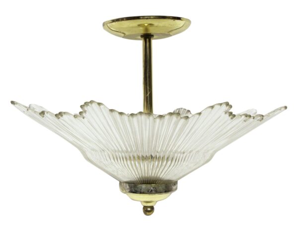 Art Deco semi flush light with a clear starburst crystal shade and polished brass frame.