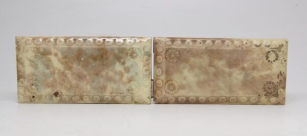 Pair of ceramic tiles with beveled edges, shown side by side with a crackled glaze and visible wear.