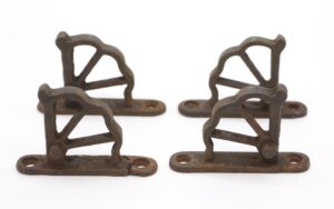 Set of four cast iron window hinge parts with a short base and staggered holes, shown in two pairs from above and at an angle.