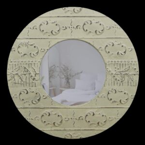 Round wall mirror with an antique white tin frame and ornate embossed detailing around the circular glass.