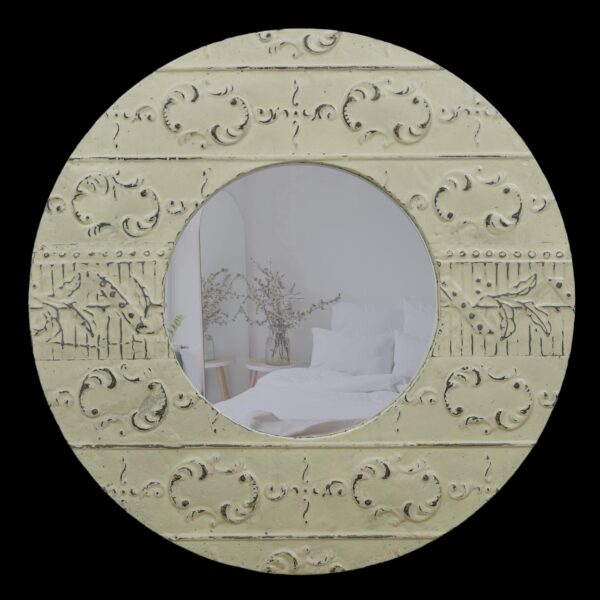 Round wall mirror with an antique white tin frame and ornate embossed detailing around the circular glass.