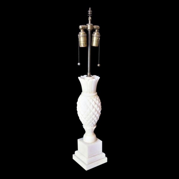 Art Deco table lamp with a carved pineapple-shaped base, brass mount, and two bulb sockets with pull chains.