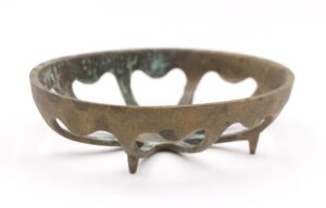 Antique oval brass soap dish with heart-shaped cutouts and three short feet.