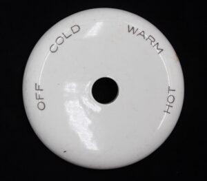Round white ceramic tub shower plate cover with a center hole, stamped Off, Cold, Warm, and Hot around the edge.