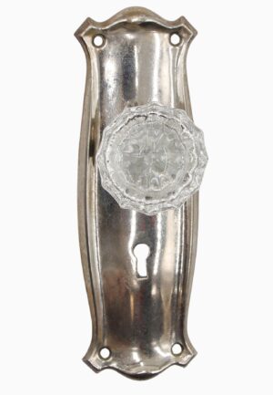Dummy door knob set with a clear fluted glass knob on a nickel-finish back plate and a keyhole opening.