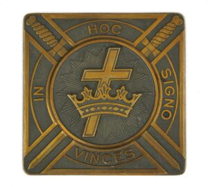 Square brass plaque with antique brass and black finish, showing a cross and crown with diagonal swords and the words “In Hoc Signo Vinces.”