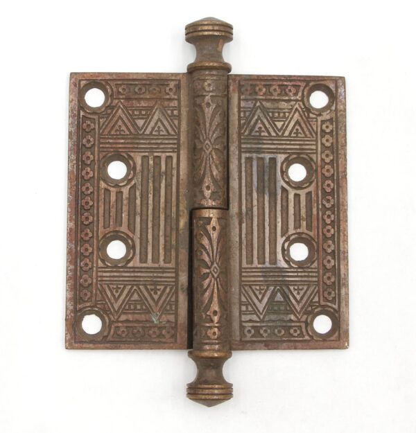 Antique bronze door hinge with ornate Aesthetic-style leaf and geometric pattern, urn tips, two knuckles, and multiple mounting holes shown front facing.