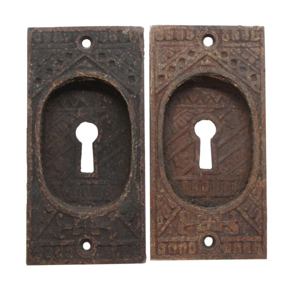 Pair of cast iron recessed door pulls with keyhole centers, shown side by side in antique bronze and black finishes.