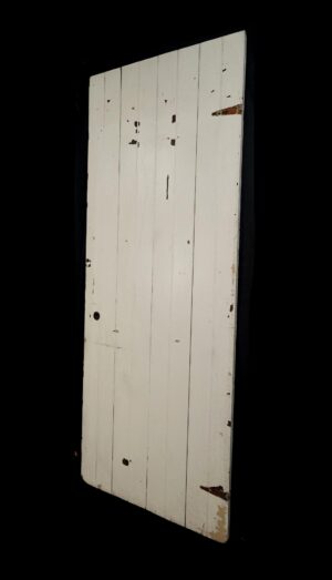 Antique four-board wood passage door painted white, shown with surface wear and chipped paint from prior use.