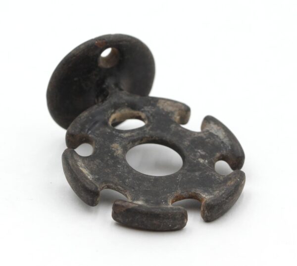 Black enameled cast iron wall toothbrush holder with five brush slots and a round mounting plate, shown with heavy surface wear and two pieces stacked together.
