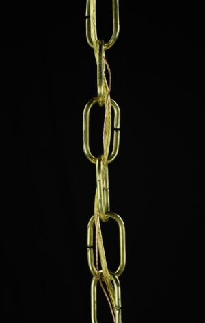 Close-up of a brass chain with linked oval sections and visible copper wire.