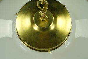 Close-up of the brass ceiling canopy and chain for a schoolhouse pendant light.