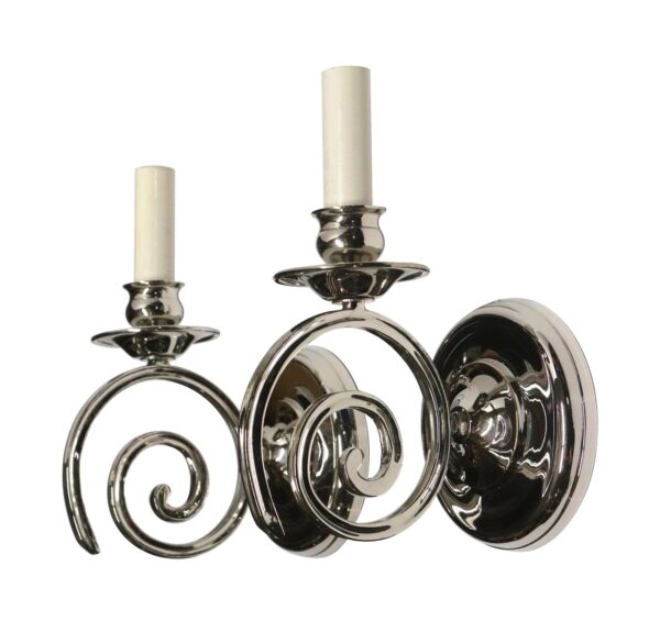 Pair of modern swirl arm sconces in polished nickel with candlestick holders and spiral arms.