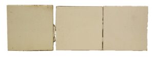 Three square white ceramic tiles with a crackled surface and minor age-related chips visible along the edges.