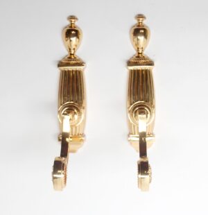Pair of polished brass towel bar brackets shown side by side, each with a traditional fluted support and a curved mounting arm.