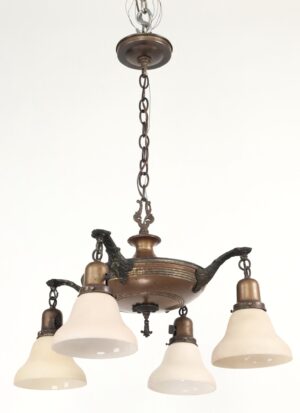 Colonial Revival brass four-arm chandelier with off-white frosted shades and a chain suspension.
