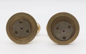 Pair of vintage polished brass dummy door knobs shown from the back, with round rosettes and visible mounting plates.