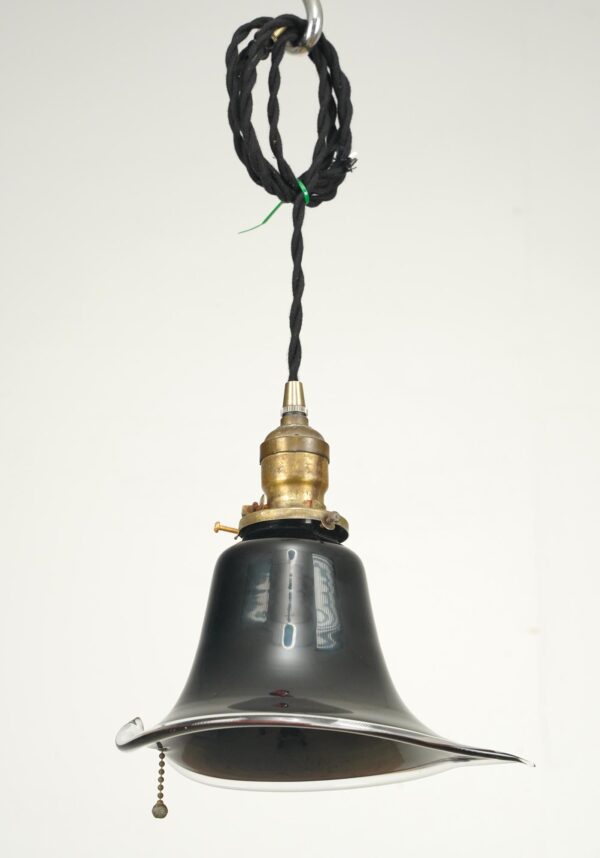 Modern pendant light with a flaring black glass shade, antique brass socket, black cord, and pull chain.