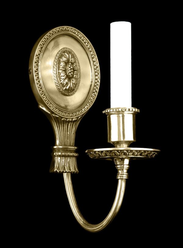Regency-style single-arm wall sconce with an oval back plate and a floral bobeche, shown in a gold finish.