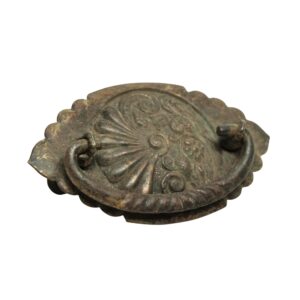 Victorian brass drawer bail pull with an antique patina and ornate oval backplate, shown in close-up.