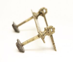 Antique brass bail drawer pull with a threaded mounting screw shown in close-up detail.