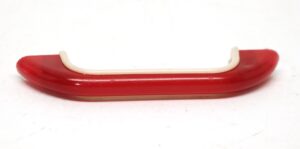 Mid century red plastic bridge pull with off white edging and a curved handle profile.