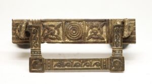 Antique brass bail drawer pull with Aesthetic-style ornament and rectangular mounting plates.