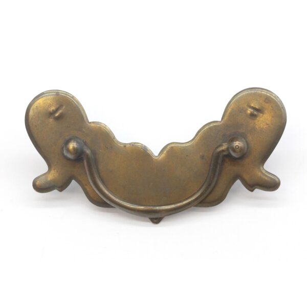 Traditional bail drawer pull with a vintage brass patina and curved handle.