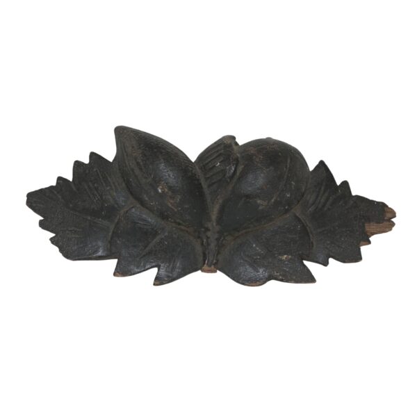 Black hand-carved wooden cup pull with a floral shape and worn edges, shown front view.