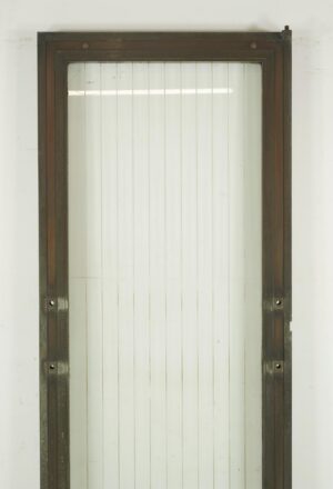 Art Deco commercial door with an antique bronze frame and a full etched striped glass panel, shown upright with hinge pockets and surface wear visible.