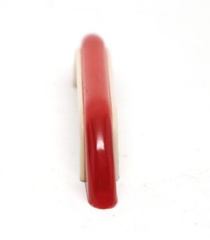 Mid century bridge drawer pull in red and off white plastic, shown upright in a front view.
