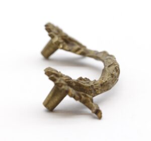 Pair of antique brass bridge drawer pulls with a curved swag shape and floral details, shown as a pair on a white background.