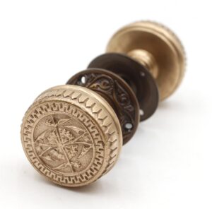 Antique brass door knob set with ornate 1880s-inspired engravings, shown from the front highlighting Branford-style detailing.