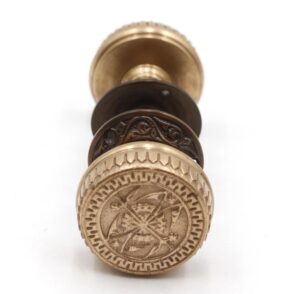 Detail view of antique brass Branford door knob featuring ornate engraving and compass motif, inspired by 1880s hardware craftsmanship.