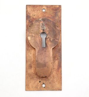 Vintage brass recessed pocket door pull in a rectangular plate with a keyhole cutout and surface wear from use.