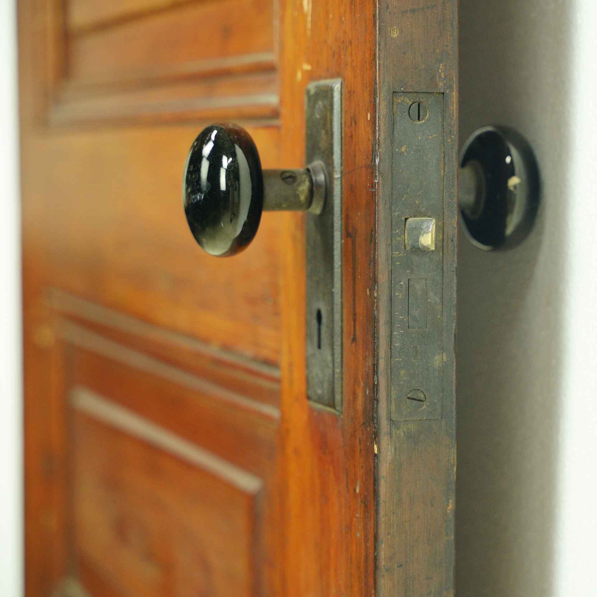Brass Mortise Lock Installed in Door with Black Porcelain Knobs