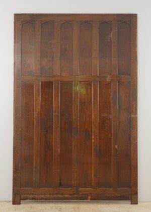Gothic oak wall panel with twelve raised sections and a dark wood tone, showing surface wear and a cut bottom edge.