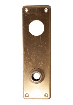 Antique brass door back plate with rounded corners, a large center opening, and a lock insert near the bottom, shown front on with four mounting holes and visible surface wear.
