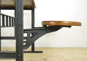 Angled view highlighting the curved metal supports and two attached round wooden seats in focus.