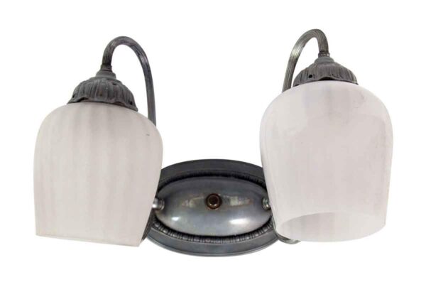 Two-light wall sconce with two white glass shades and a central nickel-plated mounting plate.